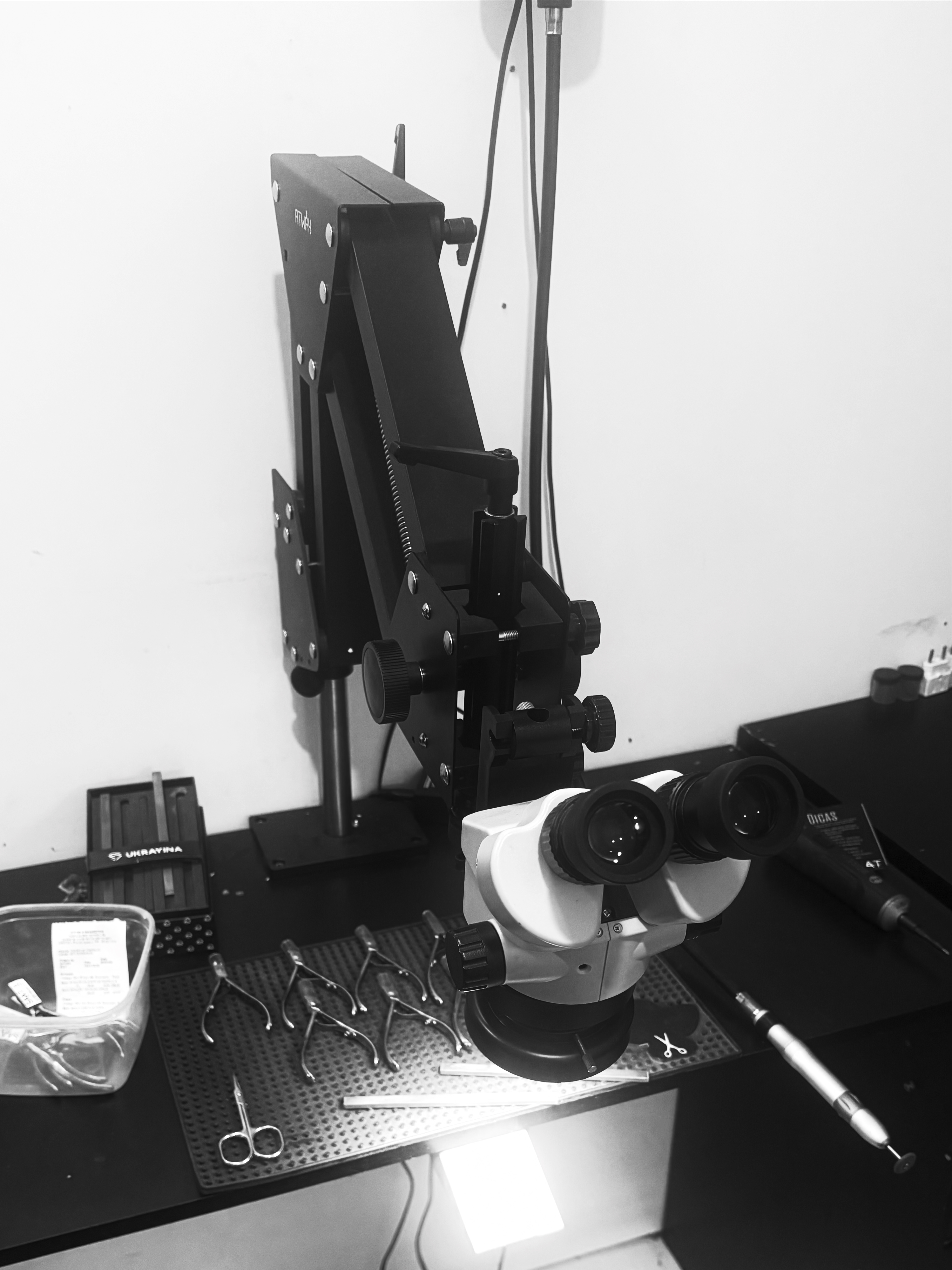 Microscópio binocular articulado e instrumentos cirúrgicos